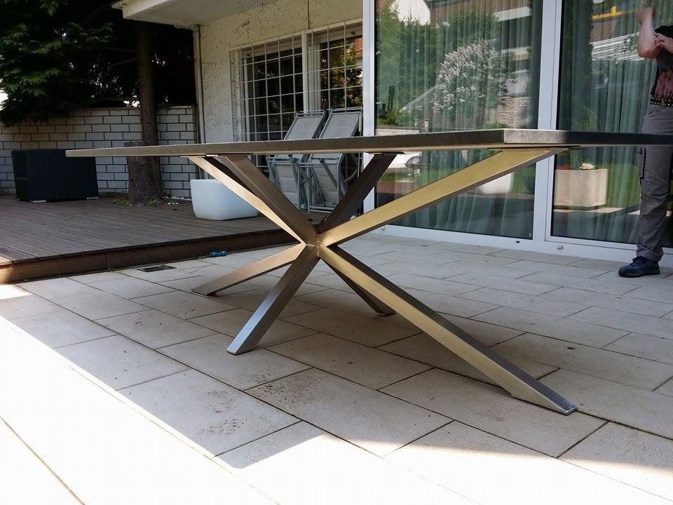 Tisch mit gekreuztem Untergestell aus Metall auf einer Terrasse